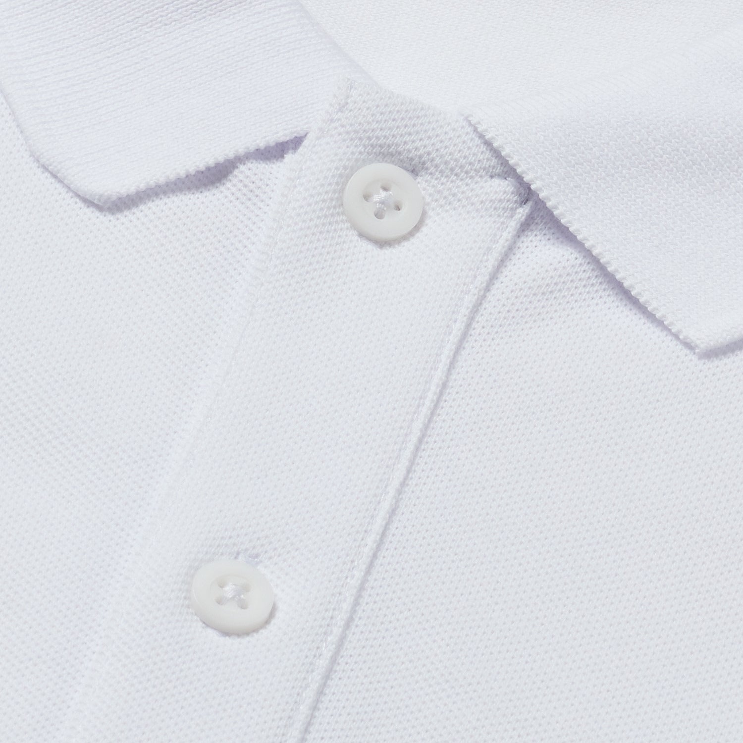 Close-up of white polo collar and buttons.